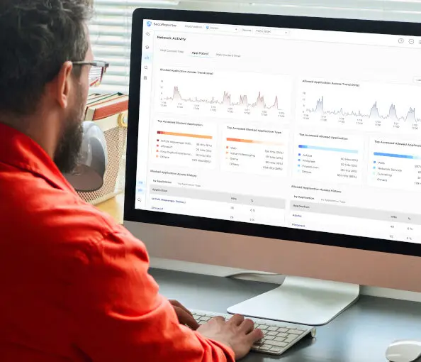 Mężczyzna przy ekranie komputera, na którym wyświetla się usługa Zyxel SecuReporter
