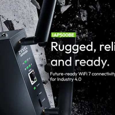Czarny punkt dostępowy Zyxel Networks IAP500BE, z dwiema zewnętrznymi antenami, umieszczony na tle gruzu i pękniętej ściany. Po prawej stronie tekst (po angielsku): "IAP500BE. Wzmocniony, niezawodny i gotowy. Przyszłościowa łączność WiFi 7 dla Przemysłu 4.0".