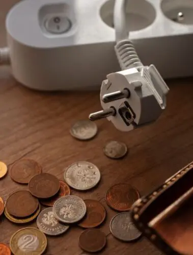 Na stoliku monety i portfel, obok listwa - przedłużacz
