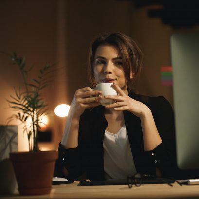 kobieta z kawa przy biurku scaled