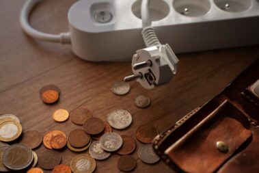 Na stoliku monety i portfel, obok listwa - przedłużacz