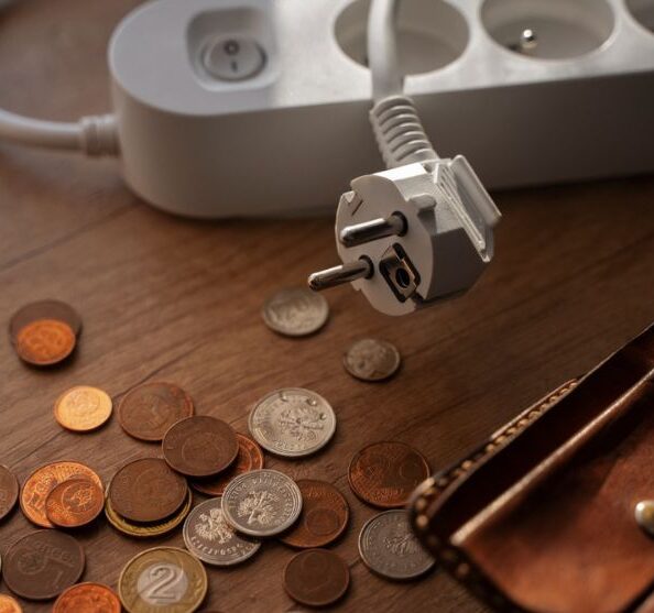 Na stoliku monety i portfel, obok listwa - przedłużacz